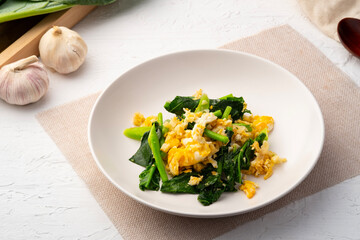 Stir fried Chinese kale with Eggs in white plate.Healthy and easy food.