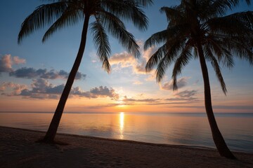 Stunning sunset over calm waters framed by palm trees at a serene beach location