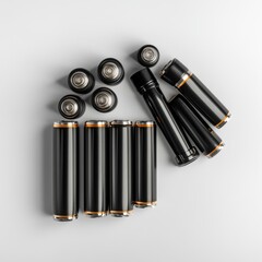Various black batteries arranged artistically on a light surface, creating a minimalist and modern aesthetic.