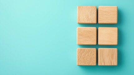 Wooden blocks arranged in a grid pattern on a vibrant turquoise background for creative design and layout concepts