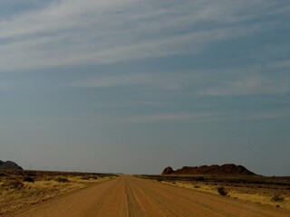 Fototapeta premium Road in Rocky and mountainous Richtersveld area illuminated by clear blue skies