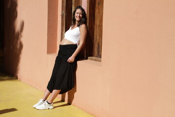 Fototapeta premium Pregnant women having sunbath at the wall of her house