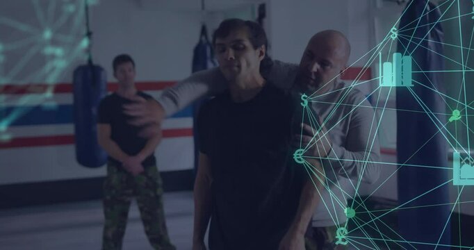 Instructor demonstrating rear naked choke on trainee in gym, showing finance chart money icons