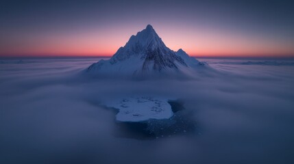 Fototapeta premium Majestic snow-covered mountain peak rising above clouds at sunset.