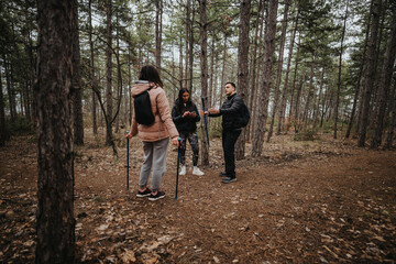 Fototapeta premium Three friends enjoy a nature walk in a scenic woodland, sharing moments and experiences while surrounded by tall trees under an overcast sky.