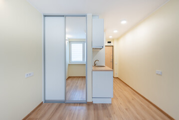 Compact Modern Apartment Interior with Wooden Flooring and Minimal Kitchen Area