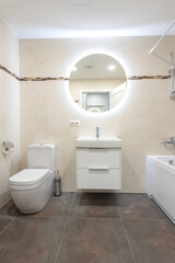Modern Home Bathroom Interior with Contemporary Fixtures and Large Circular Mirror