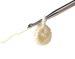Close-up of a shiny silver crochet hook with a partially formed loop, demonstrating the art of crocheting and the creation of intricate handmade textiles