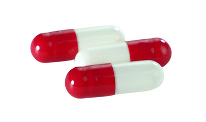 Bulk red and white capsule pills isolated on white background.