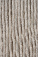 pastel texture of knitted wool fabric as a background, brown  smooth symmetrical lines of hand-knitted needlework pattern	

