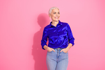 Confident Senior Businesswoman in Stylish Blue Shirt and Casual Jeans Posing with Hands in Pockets...