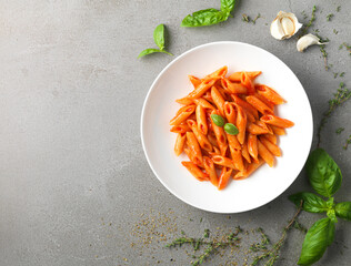 italian pasta with tomato sauce and basil on a white plate