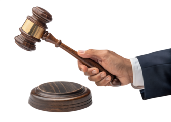 Close up of a hand in a suit holding a wooden judges gavel above a sound block