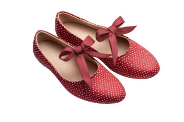 Adorable red polka dot shoes with delicate bows elegantly displayed against a stark black on transparent background