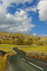 A winding country road invites a peaceful journey through the stunning Yorkshire Dales landscape.