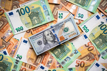 One hundred American dollars on Euro paper money banknotes background. View from above