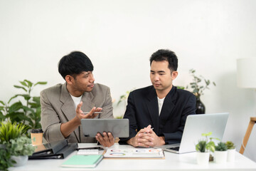 Business Discussion and Strategy. Two professionals engaging in a conversation about project ideas in a modern office.