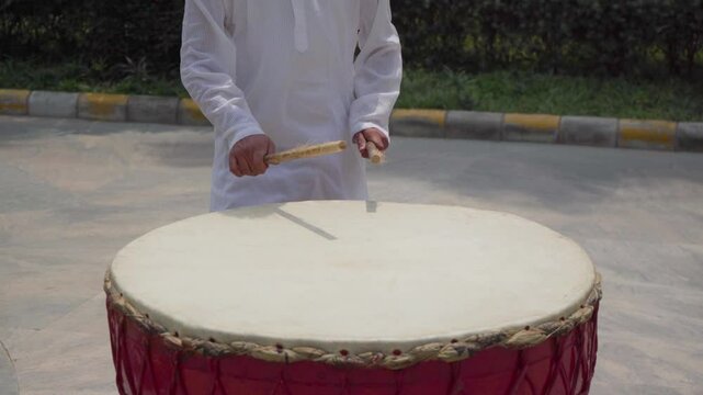 Mid Shot of Man Playing Nagada Drum
