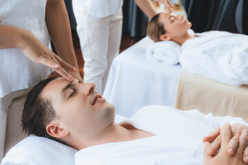 Caucasian couple enjoying relaxing anti-stress head massage and pampering facial beauty skin...