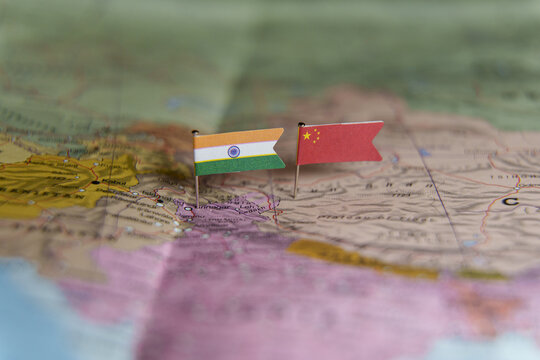 Mini flags of India and China pinned on a map showing the border area between the two countries