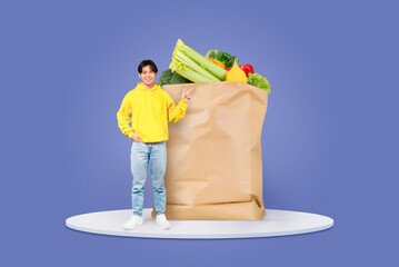 A customer stands joyfully next to a massive paper grocery bag overflowing with colorful vegetables...