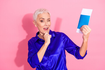 Elegant mature woman holding a document while winking playfully, showcasing confidence and charm...