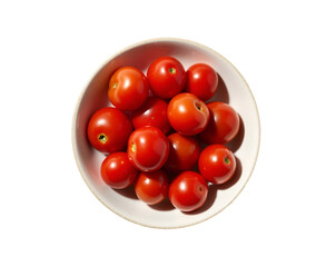 Overhead view of vibrant red cherry tomatoes in a white bowl against a minimalist, contrasting, and saturated setting, emphasizing freshness and simplicity