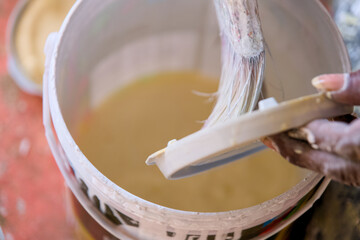 Applying paint with brush and bucket during home renovation