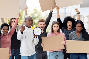 Furious multiracial students with empty placards having strike or demonstration on the street....