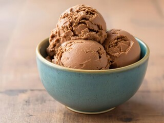 A blue bowl filled with three scoops of chocolate ice cream