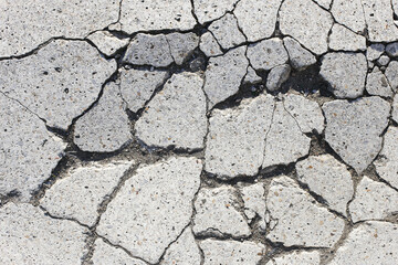 Cracked concrete surface. Urban damage texture. Broken asphalt closeup. Grey rough pattern. Destruction background. Street detail. Weathered cracked ground. Cement break structure.