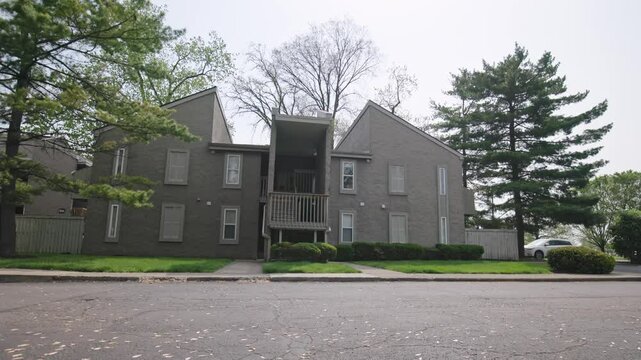 Wide shot in slow motion exterior or apartment complex townhouse and duplex for rental property outside Columbus, Ohio in Grandview Heights during a warm, spring day in the midwestern United States