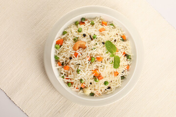Fresh steaming Vegetable Rice garnished with mint leaf served in ceramic bowl