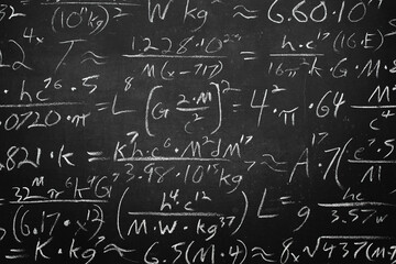 Wide blackboard inscribed with scientific formulas and calculations in physics, mathematics and...