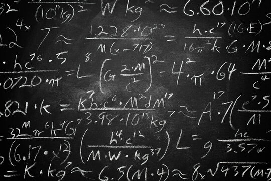Wide blackboard inscribed with scientific formulas and calculations in physics, mathematics and electrical circuits. Science and education background.