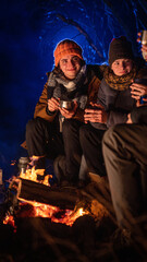 Obraz premium Friends sitting around a campfire in the woods on a winter evening