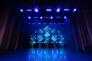 Stage illuminated by vivid red and amber lights, featuring a symmetrical truss structure with...