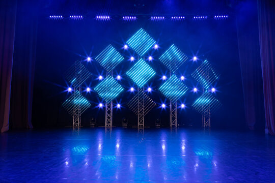 Stage illuminated with cool blue LED lights arranged in diamond patterns, creating a futuristic and balanced visual setup suitable for events or concerts.