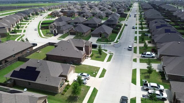 Residential street brand new suburban neighborhood modern houses solar panel roof near construction site foundation prepping, fast growing Princeton, Collin County, Texas, energy efficiency home