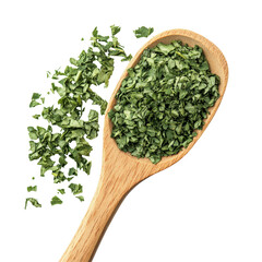 A pile of dried parsley leaves next to a wooden spoon on a transparent background showcasing culinary herbs, dry parsley leaves, pile with wooden spoon isolated on transparent background
