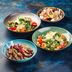 Bowls filled with different types of food, including various vegetable salads