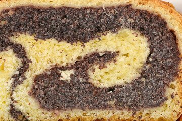A close-up shot shows a slice of poppy seed roll with a rich, dark filling swirled within a light yellow dough