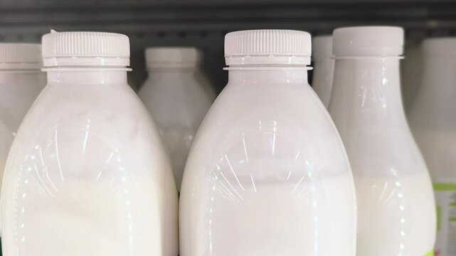 Natural kefir bottles on display in grocery store shelf. Dairy products.