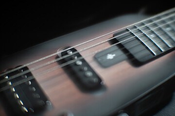 Close-up view of an electric guitar in profile, made from hardwood like mahogany or maple Multiple...