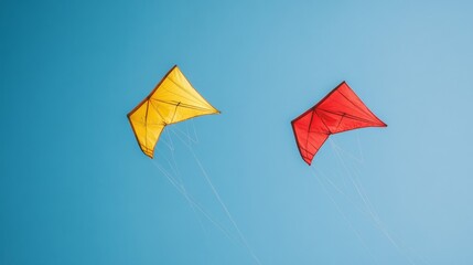 Two kites fly high in a clear blue sky