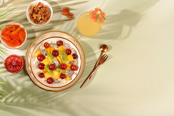 Healthy light breakfast with ingredients. Fruit salad with soft grain cottage cheese, yogurt, dragon fruit, kiwi, mango, oranges, nuts, grapes, diet healthy lifestyle advertisement, kitchen background