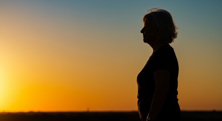 Woman Silhouette at Sunset - Serene sunset silhouette of a woman, symbolizing peace, reflection, hope, tranquility, and the passage of time
