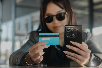 Woman Demonstrates Mobile Payments with Card and Phone, Indoors