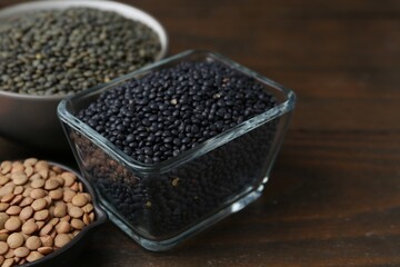 Different types of lentils on wooden table, closeup