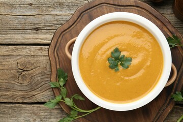 Delicious lentil cream soup with parsley on wooden table, top view